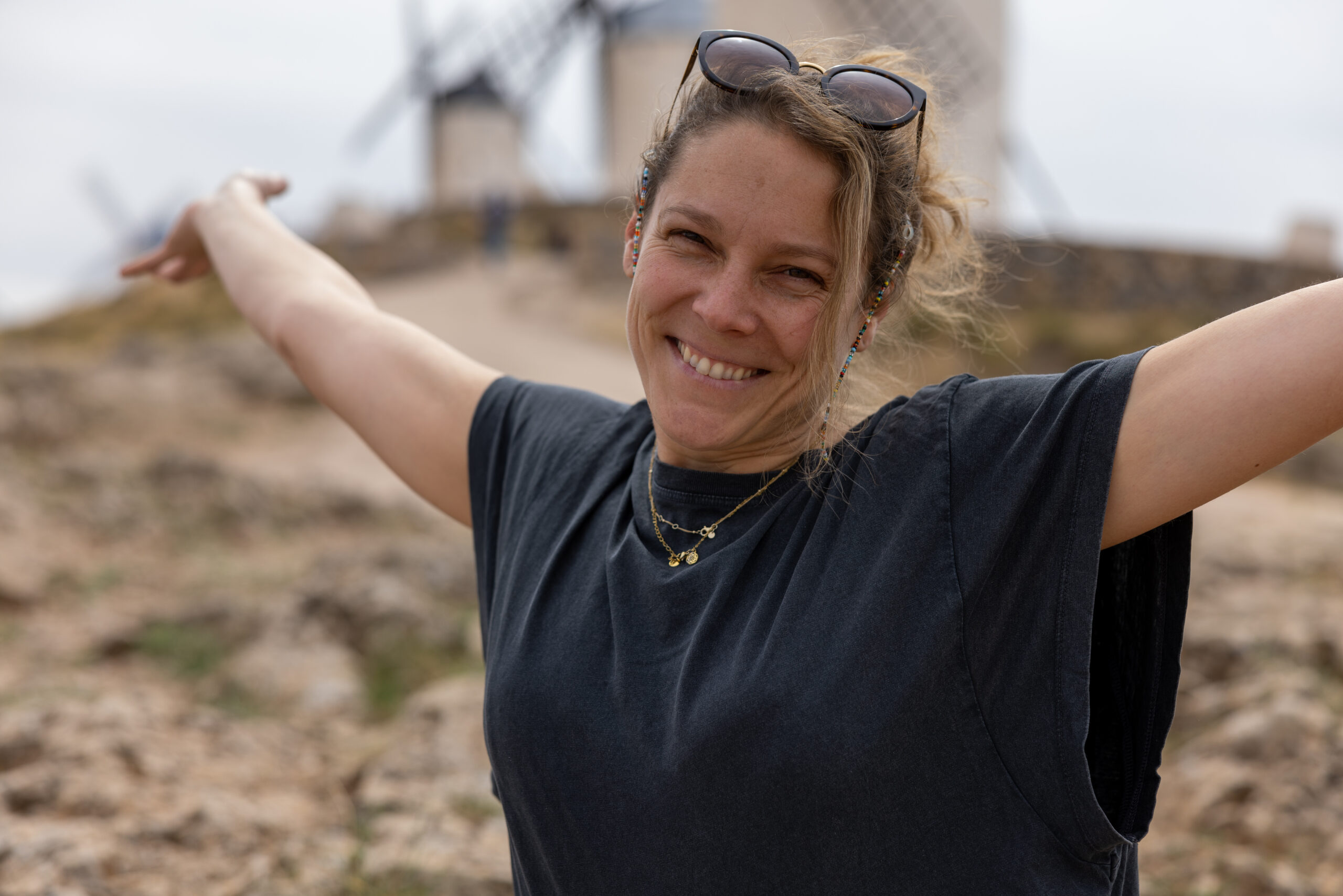 Francesca Schori mit weit ausgebreiteten Armen fröhlich und herzlich in Kamera lächelnd.