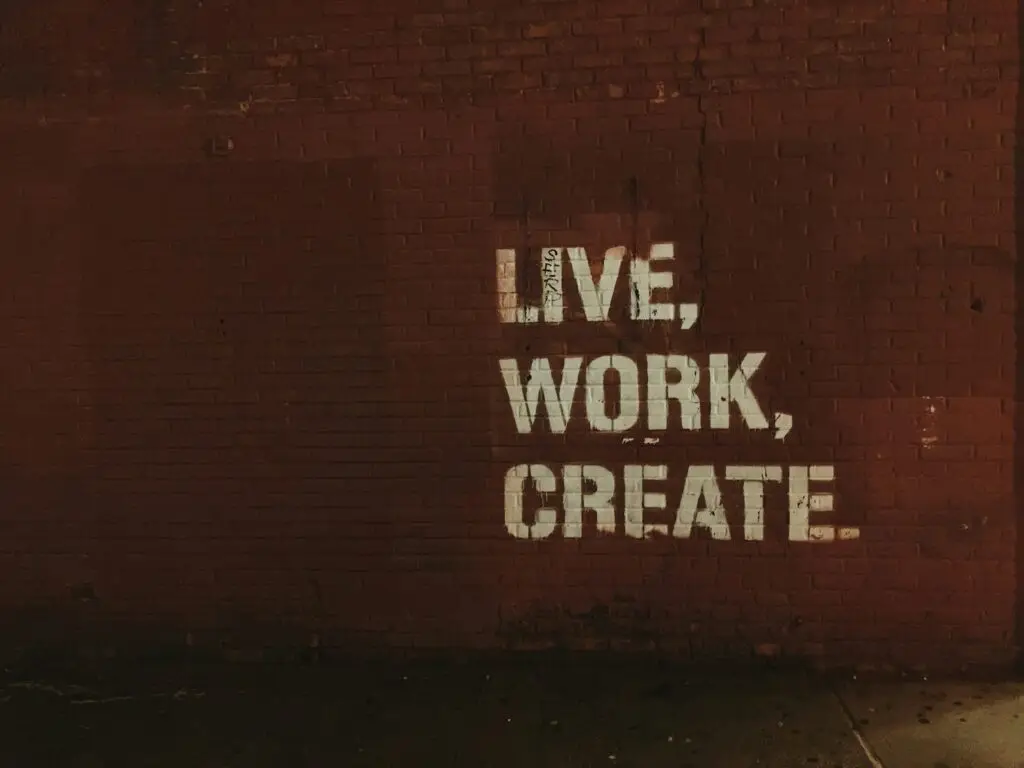 Braune Wand mit Graffity Inschrift Live, Work, Create. Jon Tyson auf Unsplash