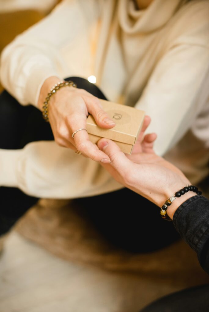 Symbolisches Geschenk für mehr Zeit und Flexibilität durch Virtuelle Assistenz Preise zwei Frauenhände Übergabe eines Geschenks Foto von Kateryna Hliznitsova auf Unsplash